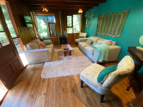 a living room with two couches and a laptop at Exquisita Cabaña familiar a minutos del Lago Caburgua y Pucón in Caburgua