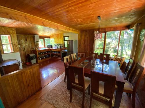 a kitchen and dining room with a table and chairs at Exquisita Cabaña familiar a minutos del Lago Caburgua y Pucón in Caburgua