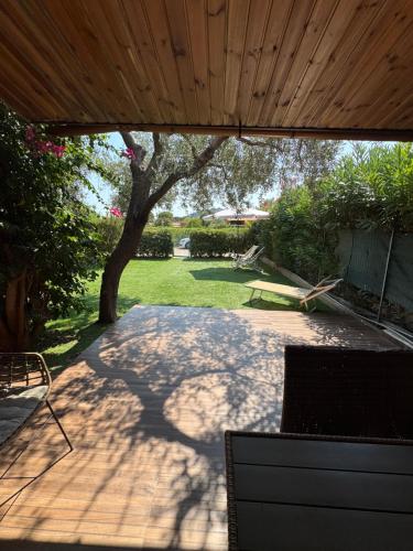 a patio with a wooden ceiling and a tree at Domu Mea 1 min a Piedi dal Mare in Costa Rei