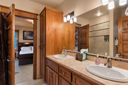 a bathroom with two sinks and a large mirror at Luxe Artful Mountain Retreat with 4 King Suites, 8 Person Hot Tub and 3 Decks in Carbondale