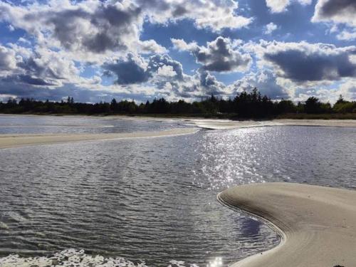 a body of water with a beach and clouds at 6 person holiday home in Hals-By Traum in Hals