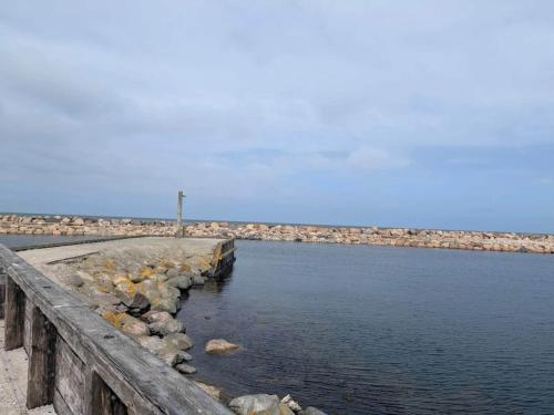 a body of water with rocks and a pier at Luxury Retreat by Bonnerup - By Traum Ferienwohnungen in Glesborg