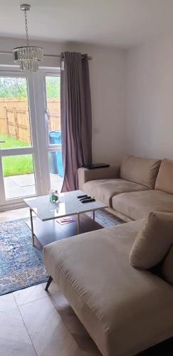 a living room with a couch and a coffee table at Modern Home with Private Garden and Car Park in Manchester in Little Hulton
