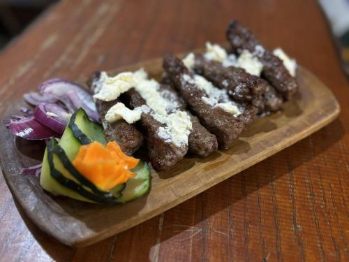 a plate of food with meat and vegetables on a table at Etno kuća Biblioteka in Smederevo