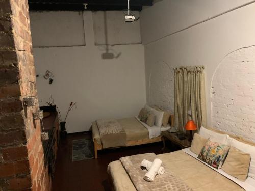 a small room with two beds and a couch at Casa Samor La Candelaria in Bogotá