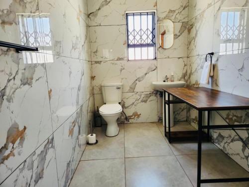 a bathroom with a toilet and a sink at Mthiyane Dam View in Hartbeespoort