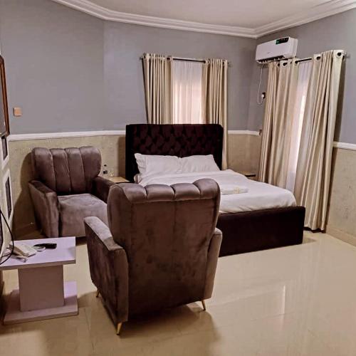 a bedroom with a couch and a bed and a chair at International royal hotel in Owerri
