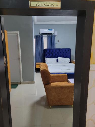 a bedroom with a bed and a chair and a bed at International royal hotel in Owerri