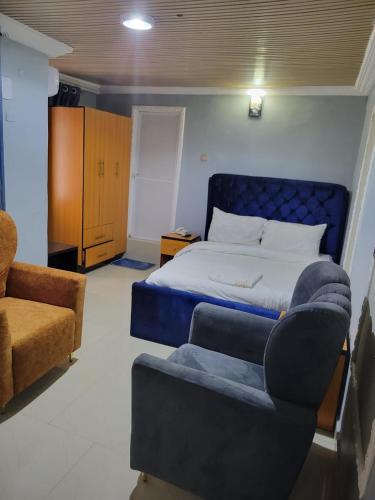 a bedroom with a bed and a couch and a chair at International royal hotel in Owerri