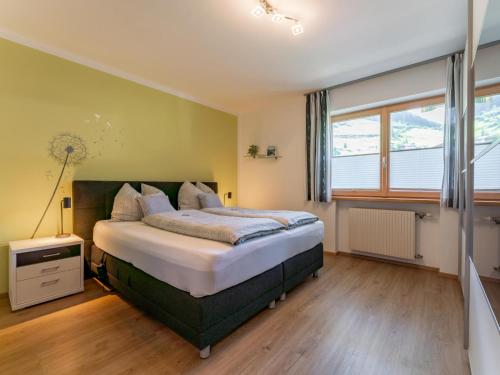 ein Schlafzimmer mit großem Bett und Fenster in der Unterkunft Pihapper in Mittersill