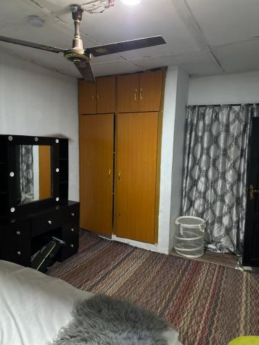 a bedroom with a bed and a dresser and a mirror at Supersonic apartment in Benin City