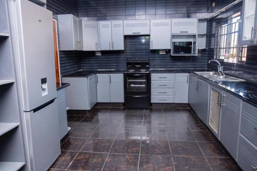 a kitchen with white cabinets and a black appliances at 47 The Heights, Area 47, Sector 1, Lilongwe in Lilongwe