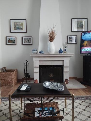 a living room with a table and a fireplace at Casa azul in Gouveia