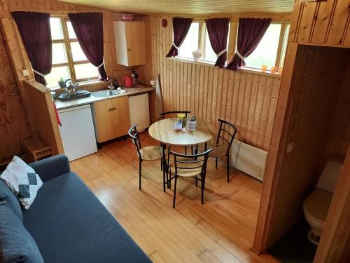 a kitchen and dining room with a table and chairs at Hænuvík Cottages in Örlygshöfn
