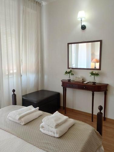 a bedroom with two beds and a vanity and a mirror at Casa azul in Gouveia