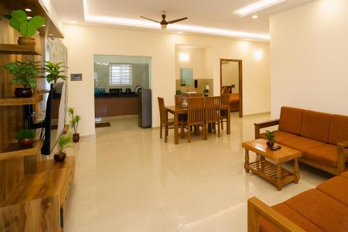 a living room with a couch and a table at TrueLife Presidential Suites - 3BHK Luxurious AC Apartments - Breakfast Included - Best Location - Modular Kitchen - Super fast WiFi, 55 Smart TV, 250 Jio Channels - RO water system -3 bathrooms - Easy access to all Temples - Top service with lots of love in Tirupati