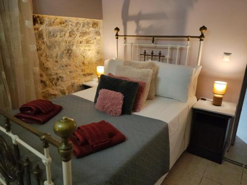 a bedroom with a white bed with pillows on it at CASA THEOTOKI in Anemómylos
