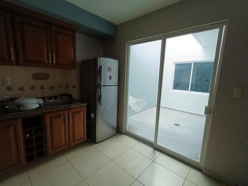 a kitchen with a refrigerator and a sliding glass door at NSI Casa Entera en La Piedad