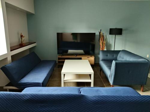 a living room with two blue couches and a table at NSI Casa Entera en La Piedad