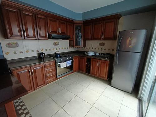 a kitchen with wooden cabinets and a stainless steel refrigerator at NSI Casa Entera en La Piedad