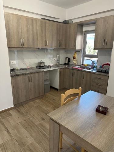 a kitchen with wooden cabinets and a wooden table at La casa de Alex in Sarandë