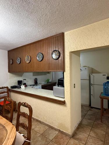 a kitchen with wooden cabinets and a white refrigerator at Casa La Cañada216 con Alberca Climatizada in Cuernavaca