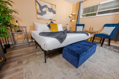 サラソタにあるArtsy Getaway with Vibrant Design Flairのベッドルーム1室(ベッド1台、青い椅子2脚付)