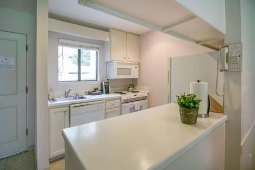 a kitchen with white cabinets and a white refrigerator at The Napa Residences in Napa