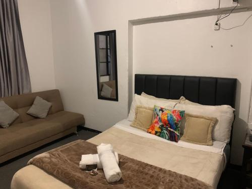 a bedroom with a large bed and a couch at Casa Samor La Candelaria in Bogotá