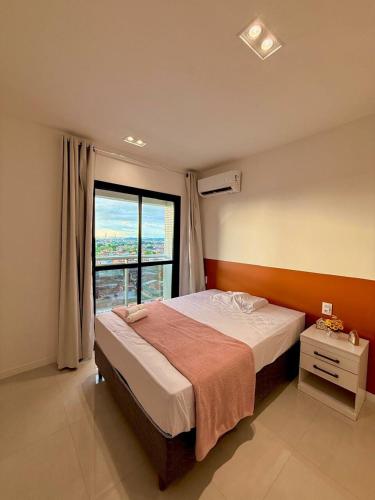 a bedroom with a bed and a large window at Conforto e praticidade em região central de Belém in Belém