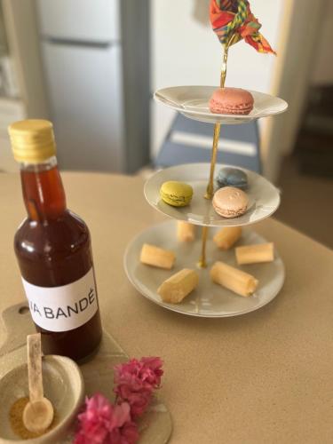 a bottle of honey next to a plate of cookies and a plate of cheese at L'Écrin du colibri, a haven of peace in Martinique in Le Robert