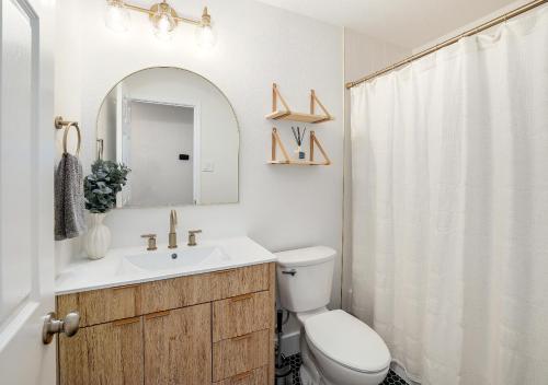 Un baño con lavabo, inodoro y espejo. en Cozy North Austin Getaway Peaceful Near Domain, en Austin