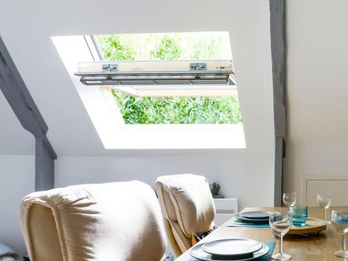 a dining room with a table and chairs and a window at Romantic Escape in Normandy in Isigny-sur-Mer