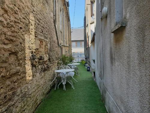 a row of tables in an alley between two buildings at Romantic Escape in Normandy in Isigny-sur-Mer