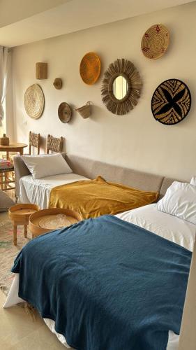 a bedroom with two beds and a mirror on the wall at Authentic Taghazout in Taghazout