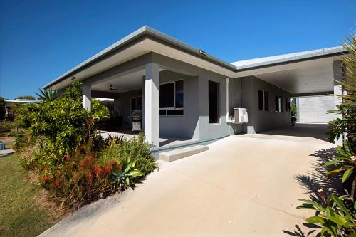 a house with a driveway in front of it at Tranquillity by the Sea in Hideaway Bay