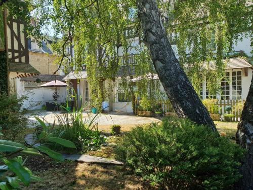 a house with a yard with a tree at Seaside Serenity in Normandy in Isigny-sur-Mer