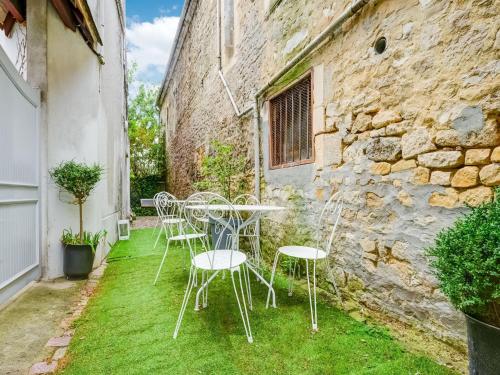 a table and chairs on the grass in front of a building at Seaside Serenity in Normandy in Isigny-sur-Mer