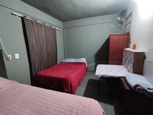 ein kleines Zimmer mit 2 Betten und einem Stuhl in der Unterkunft Alojamiento S&R in Encarnación