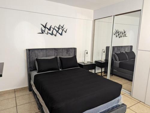 a bedroom with a black bed and a mirror at Casa Marlet Vieques in Vieques