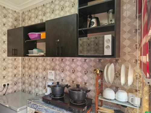 a kitchen with a stove with pots and pans at Clark Residences & Bar Limited in Uyo