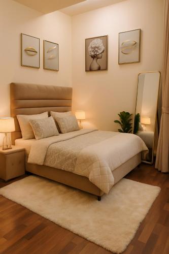 a bedroom with a bed with two lamps and a rug at Montressa Hotel Apartments-Elysium Tower Opposite Centaurus Mall Islamabad in Islamabad