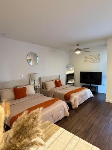 a bedroom with two beds and a flat screen tv at The Hollywood Blvd Loft FREE AND DESIGNATED PARKING in Los Angeles