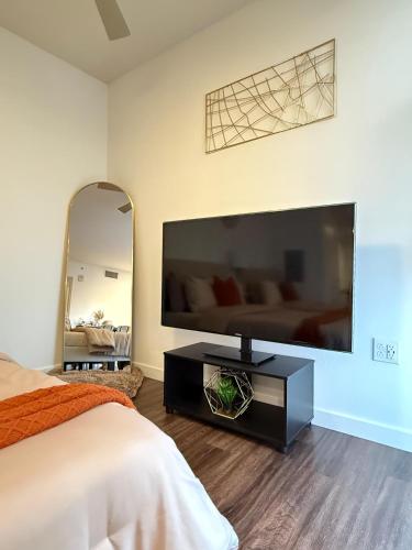 a bedroom with a large flat screen tv on a wall at The Hollywood Blvd Loft FREE AND DESIGNATED PARKING in Los Angeles