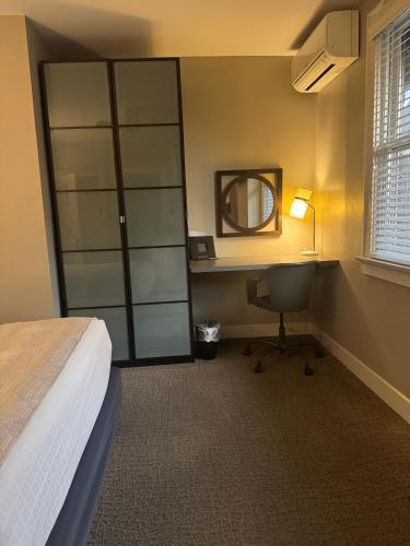 a bedroom with a bed and a desk and a mirror at Bexley Bed and Breakfast in Columbus