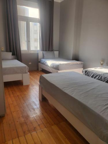 a room with three beds and a window at nice comfy bedroom in Cairo