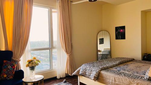 a bedroom with a bed and a mirror and a window at Montressa Hotel Apartments-Elysium Tower Opposite Centaurus Mall Islamabad in Islamabad