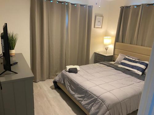a bedroom with a bed and a desk and a television at Private Room in Spacious 3-Bedroom Home in Fort Lauderdale
