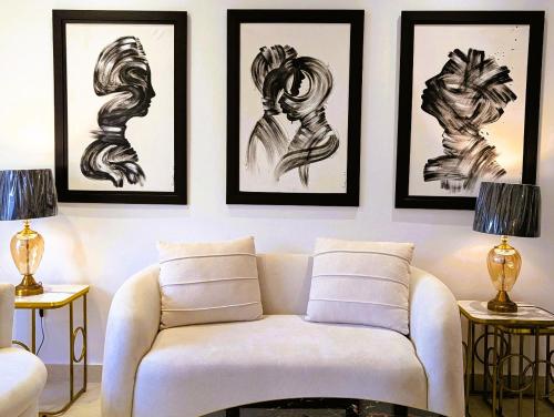 a living room with a couch and some drawings on the wall at Montressa Hotel Apartments-Elysium Tower Opposite Centaurus Mall Islamabad in Islamabad