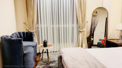 a bedroom with a bed and a chair and a mirror at Montressa Hotel Apartments-Elysium Tower Opposite Centaurus Mall Islamabad in Islamabad